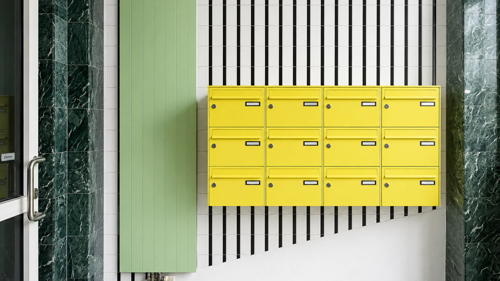 Foyer des GODU mit gelben Briefkästen, mintgrünen Wandflächen und grafischem Fliesendesign