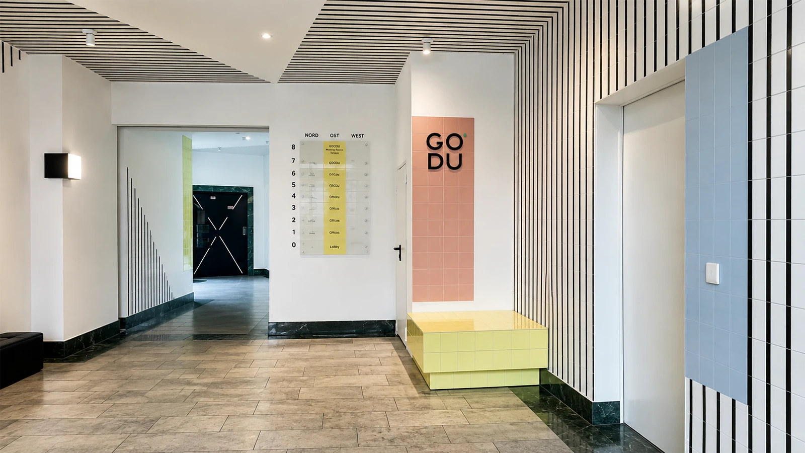 Foyer des GODU mit farbiger Wegweisung, Sitzbank und grafischem Wanddesign
